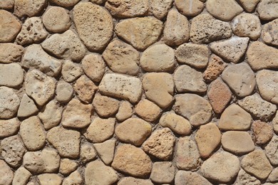 Texture of beige stone wall as background, closeup