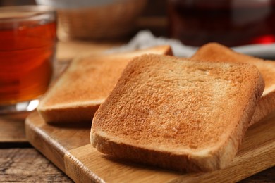 Slices of tasty toasted bread on wooden table, closeup