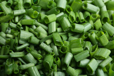 Cut green spring onions as background, closeup