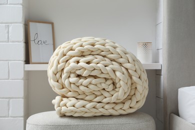 Soft chunky knit blanket on ottoman indoors