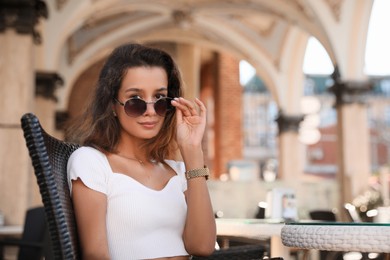 Photo of Portrait of beautiful young woman in outdoor cafe