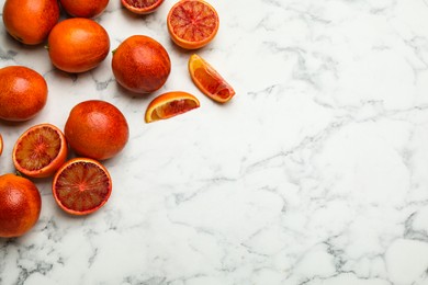 Many ripe sicilian oranges on white marble table, flat lay. Space for text