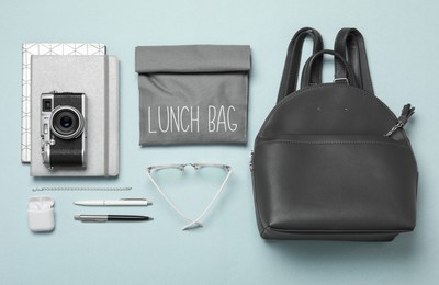 Stylish urban backpack with different items on light background, flat lay