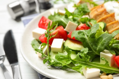 Delicious salad with chicken, arugula and tomatoes on plate, closeup
