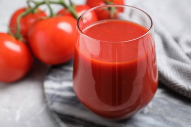 Delicious fresh tomato juice in glass on table, closeup