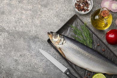 Photo of Delicious salted herring and ingredients on grey table, flat lay. Space for text