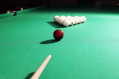 Striking ball with cue on billiard table
