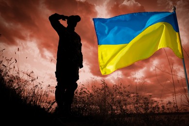 Stop war in Ukraine. Silhouette of soldier saluting to Ukrainian flag outdoors, toned in red