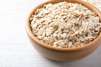 Bowl with oatmeal on white wooden table