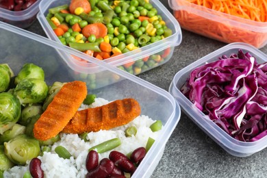 Set of plastic containers with fresh food on grey   table, closeup