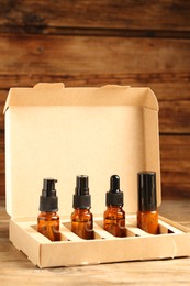 Bottles with oil in box on wooden table. Natural cosmetics