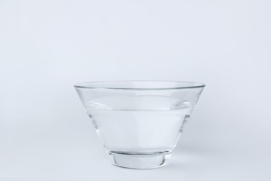 Glass bowl full of water on white background