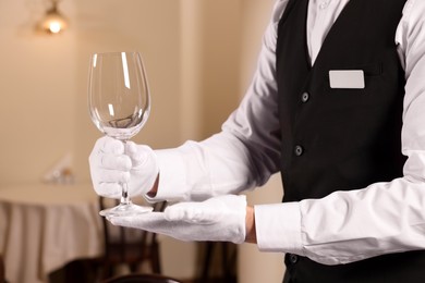 Photo of Man setting table in restaurant, closeup. Professional butler courses