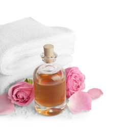 Spa composition with oil, pink flowers and towels on white background