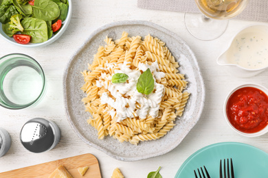 Flat lay composition with tasty pasta on white wooden table