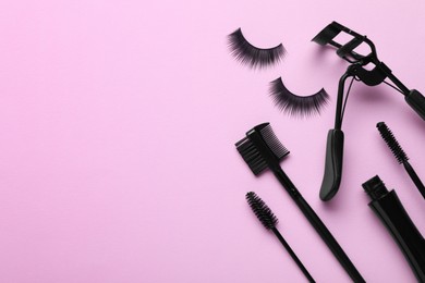 Photo of Flat lay composition with fake eyelashes on pink background, space for text