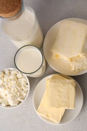 Photo of Tasty homemade butter and dairy products on white textured table, flat lay