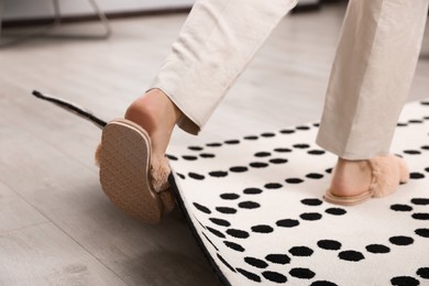 Photo of Woman tripping over carpet at home, closeup