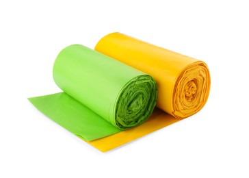 Rolls of green and yellow garbage bags on white background