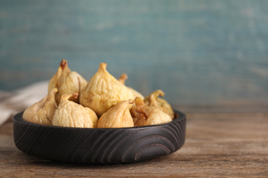 Tasty dried figs in plate on wooden table