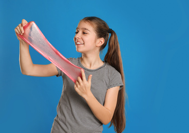 Photo of Preteen girl with slime on blue background