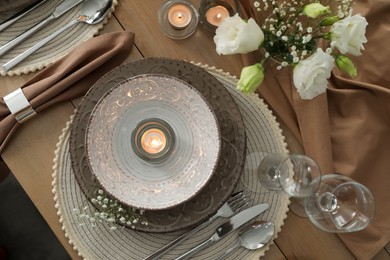 Festive table setting with beautiful candles and floral decor, flat lay