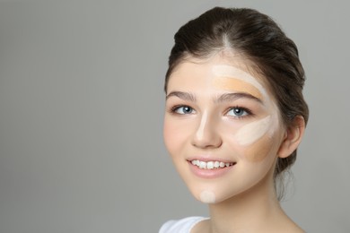 Photo of Beautiful girl on grey background. Using concealers and foundation for face contouring