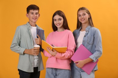 Group of teenage students with stationery on yellow background