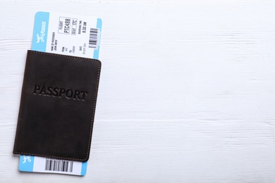 Passport with ticket on white wooden table, top view and space for text. Travel agency concept