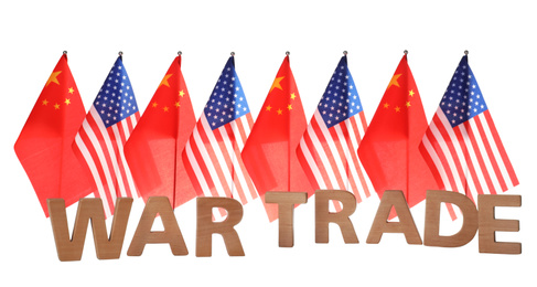 USA and China flags behind phrase WAR TRADE of wooden letters on white background