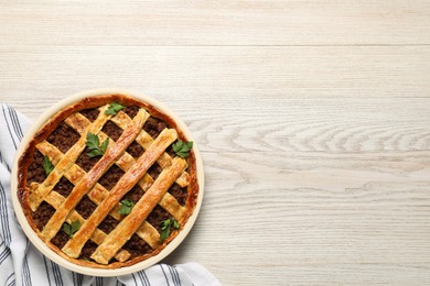 Photo of Freshly baked meat pie on white wooden table, top view. Space for text