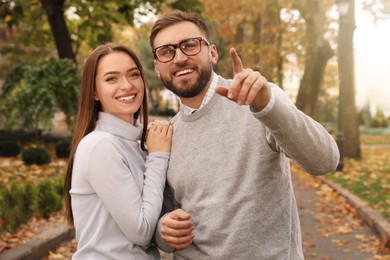 Photo of Happy couple wearing stylish clothes in autumn park