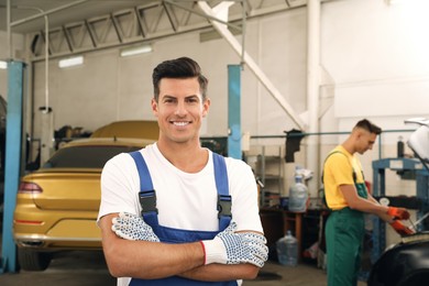 Photo of Portrait of professional mechanic at automobile repair shop