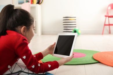 Photo of Little girl using video chat on tablet in playroom. Space for text