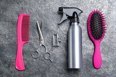 Flat lay composition of professional scissors and other hairdresser's equipment on grey table. Haircut tool