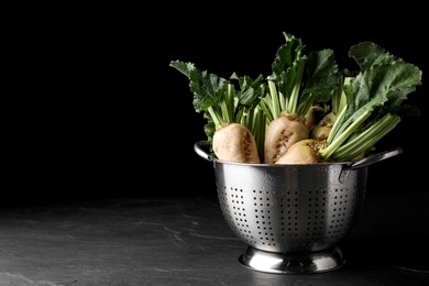 Photo of Colander with fresh sugar beets on black table. Space for text