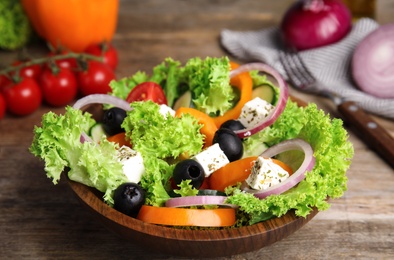Tasty fresh Greek salad on wooden table, closeup