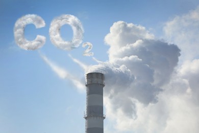  Inscription CO2 made of smoke. Polluting air from industrial chimney outdoors against blue sky 