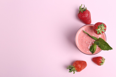 Tasty strawberry smoothie with mint in glass on pink background, flat lay. Space for text
