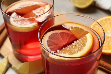 Glasses with aromatic punch drink on table, closeup view