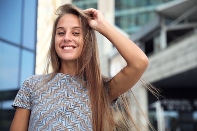 Portrait of beautiful young woman near building outdoors