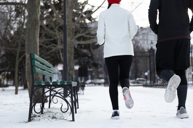 People running in winter park, closeup. Outdoors sports exercises