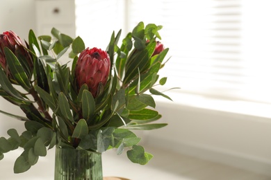 Photo of Vase with bouquet of beautiful Protea flowers indoors, closeup