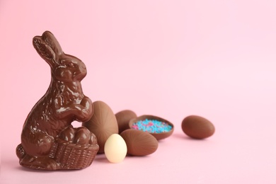 Chocolate Easter bunny and eggs on pink background. Space for text