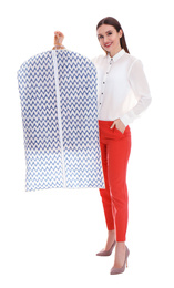 Young woman holding hanger with clothes in garment cover on white background. Dry-cleaning service