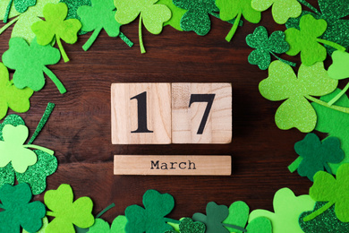 Flat lay composition with block calendar on wooden background. St. Patrick's Day celebration