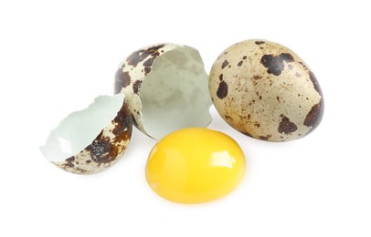 Whole and cracked quail eggs on white background
