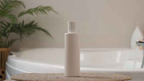 White bottle of bubble bath on tub indoors