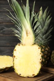 Photo of Cut fresh juicy pineapple on wooden board