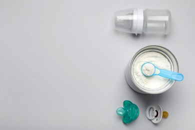 Flat lay composition with powdered infant formula on light background, space for text. Baby milk